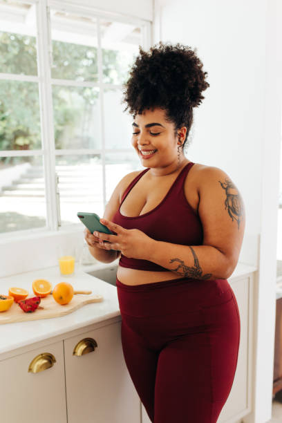 istock Healthy woman checking cell phone in kitchen 1330510280