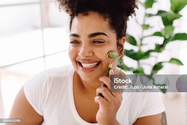 Happy Woman Using Beauty Tool Stock Photo - Download Image Now - Facial Massage, Jade Roller, One Woman Only