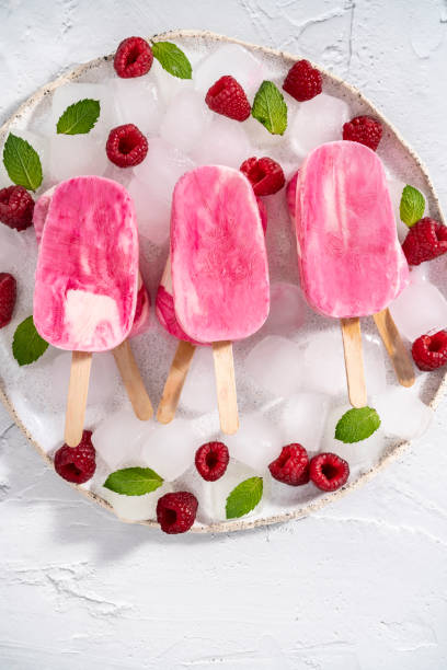 istock Raspberry berries homemade popsicles with mint leaves on ice cubes in white plate 1330510350