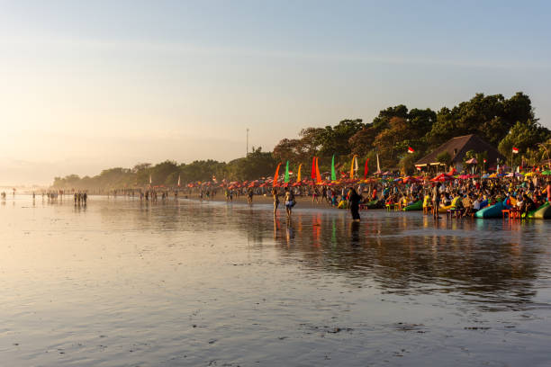 Seminyak beach in Bali Kuta, Indonesia - September 14, 2018: Tourists and locals strolling and enjoying sunset at Seminyak beach in Bali. It is one of tourists attraction in this area. kuta beach stock pictures, royalty-free photos & images