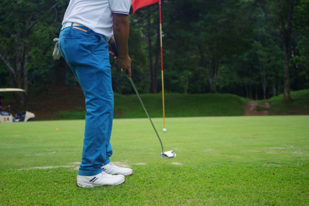гольфисты ставят гольф на вечернем поле для гольфа на закате солнца - short game стоковые фото и изображения
