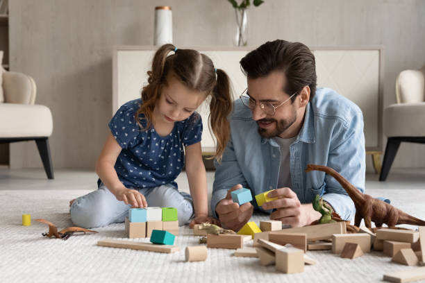 istock Loving father lying on floor, having fun with little daughter 1330511752