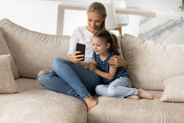 istock Happy mother with adorable little daughter using smartphone together 1330511892