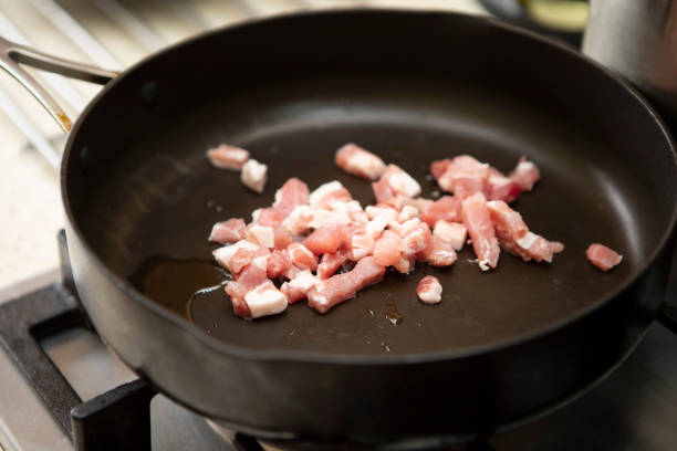 istock Raw bacon lardons in a black frying pan 1330519411