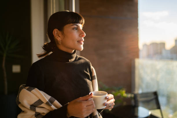 istock Young woman contemplating and drinking tea at home 1330522849