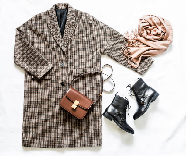 istock Women's autumn spring clothing  - oversized plaid coat, leather black boots, leather bag, beige cashmere scarf on a light background, top view. Fashion concept 1330528666