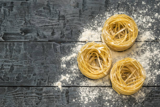 istock Flour and pasta on a black wooden table. Space for the text. 1330532865