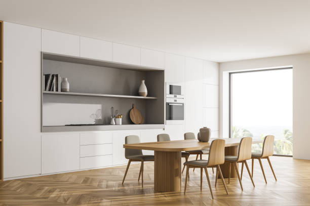 istock Light kitchen interior with dining table and chairs on wooden floor, window 1330535776