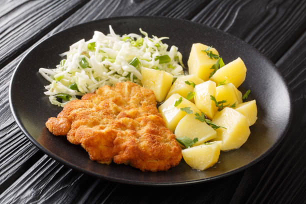 istock Fried pork cutlet breaded served with potatoes and cabbage salad close-up in a plate. horizontal 1330536031