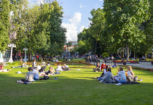 People are resting at the Moscow Hermitage Garden or Hermitage park during warm sunny day in Russia.