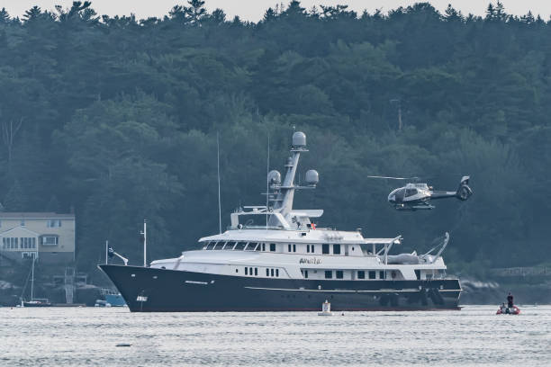 Helicopter Landing on Luxury Yacht Boothbay, Maine, USA-July 12, 2021: Helicopter coming in for a landing on luxury yacht anchored in Boothbay Harbor helicopter landing on yacht stock pictures, royalty-free photos & images