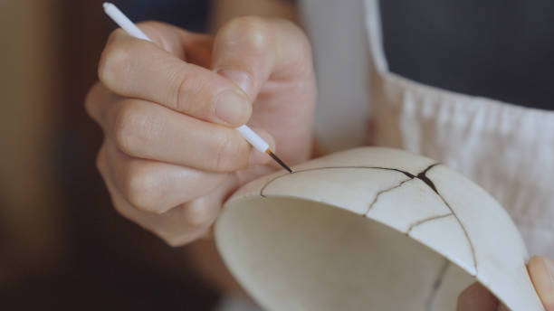 istock Woman repairing broken pottery. Kintsugi. 1330540421
