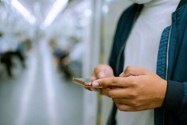 istock Man traveling by subway train  wearing protective mask during coronavirus outbreak  using phone. 1330544381