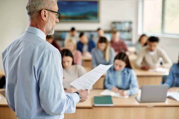 istock Mature university professor giving lecture to his students in the classroom. 1330545921