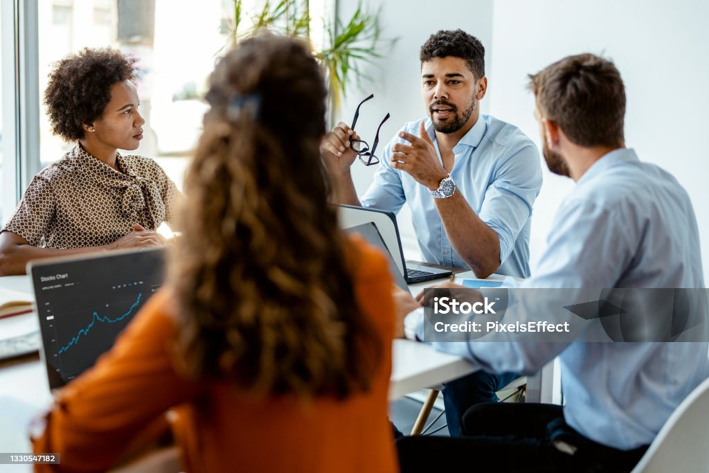 We're always hungry for success Confident and successful team. Group of young modern people in smart casual wear discussing business while sitting in the creative office Meeting Stock Photo