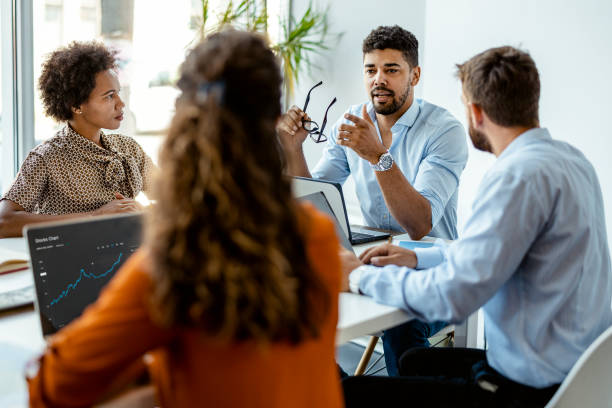 We're always hungry for success Confident and successful team. Group of young modern people in smart casual wear discussing business while sitting in the creative office place of work stock pictures, royalty-free photos & images