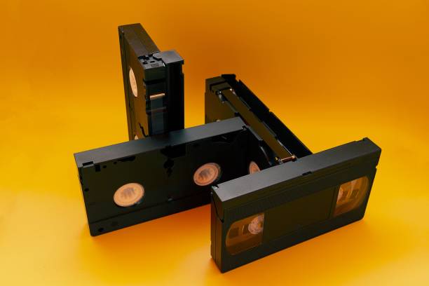 istock obsolete retro technology object four VHS video tapes in different positions on orange background 1330547998