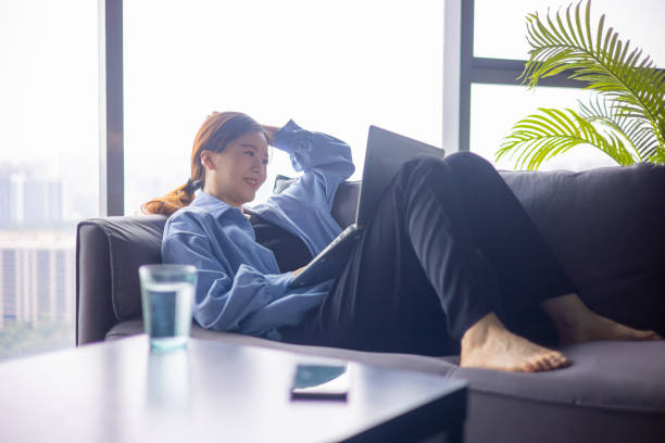 istock Young women using laptop at home,sitting on sofa 1330550822