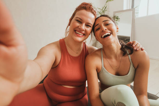 amigas em estúdio de fitness tirando selfie - friendship women two people exercising - fotografias e filmes do acervo