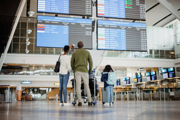 istock Family looking at flight information display in airport 1330555885