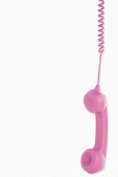 istock Dangling Retro Pink Telephone Receiver 1330556158