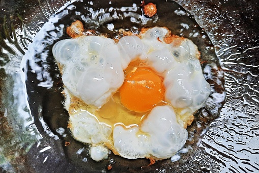 Fried egg on cooking pan.