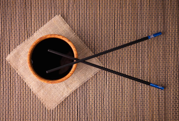 sojasauce und essstäbchen auf einer bambusmatte, draufansicht. - fruit table bamboo black stock-fotos und bilder