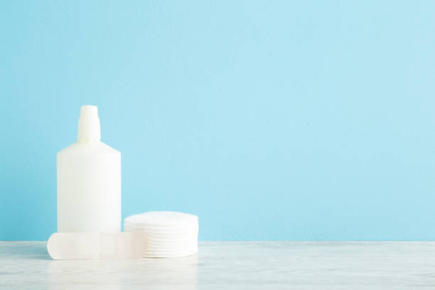 istock White bottle of hydrogen peroxide, stack of cleansing cotton pads and adhesive bandage on table at light blue wall background. Pastel color. Medical kit for skin wound cleaning. Empty place for text. 1330560101