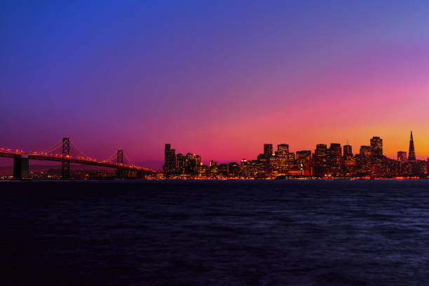 San Francisco skyline and cityscape at night, skyscrapers and Oakland Bay Bridge, purple sky, magical view