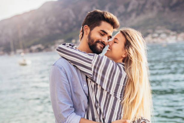 istock Happy young couple laughing and hugging on the beach 1330563663