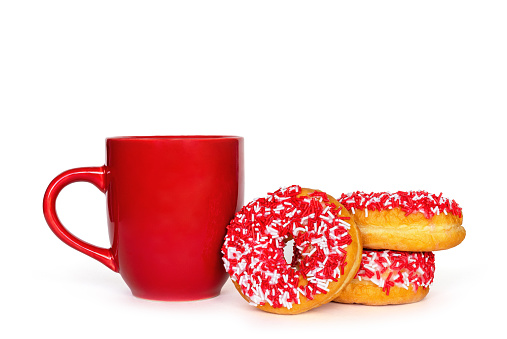 Three red donuts and cup isolated on white background with copy space. Mug with tea or coffee and dessert. Sweet food