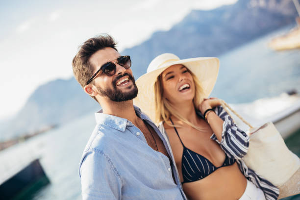 istock Happy young couple laughing and hugging on the beach 1330565974