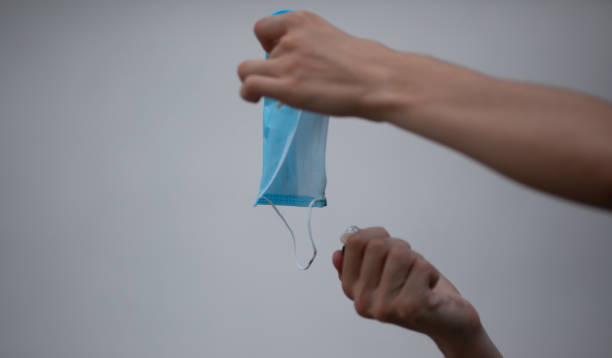 istock Hand holding a lighter sets fire to a medical mask 1330566930