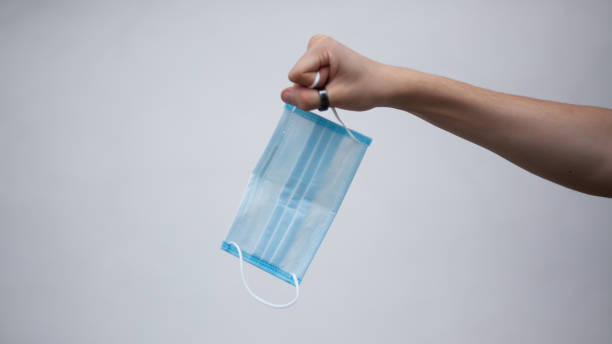 istock Hand holding a medical mask 1330566998