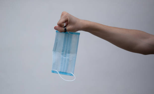 istock Hand holding a medical mask 1330567007