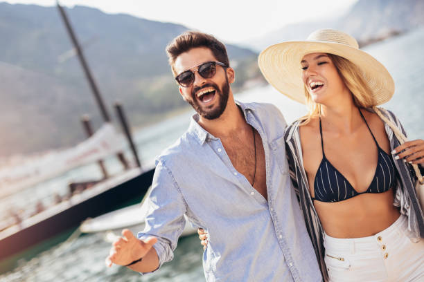 istock Happy young couple laughing and hugging on the beach 1330567353