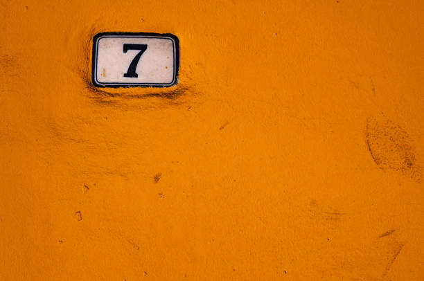 istock house number 7 on ceramic table on yellow wall. copy space 1330571919