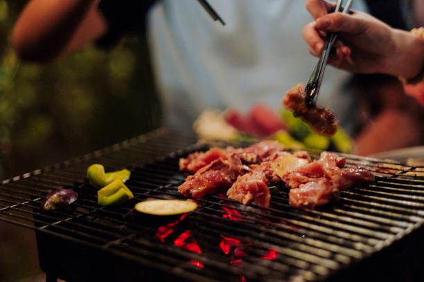 istock Family making barbecue in dinner party camping at night 1330578452