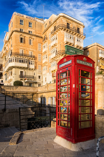 Red phone box over Victoria Gate bridge in Valletta old town, Malta