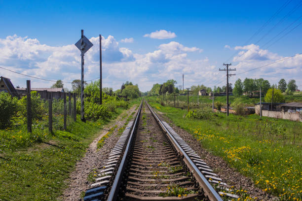 single track railway in countryside in summer under blue sky with white clouds