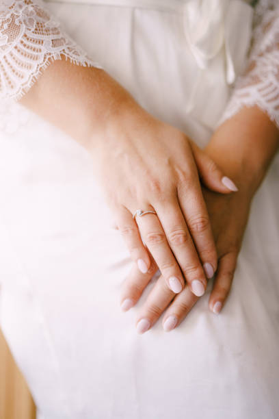 istock Bride in white dress folded her hands in her lap 1330584665