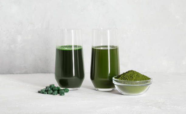 istock Chlorella and spirulina green drinks on a white concrete background. Spirulina tablets and chlorella powder. Superfood concept. Detox drinks. Copy space. 1330587562