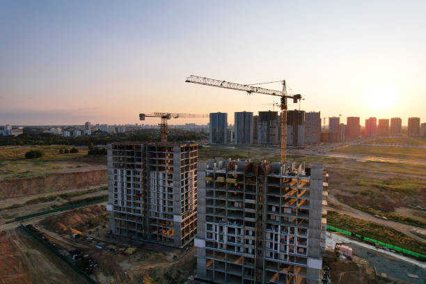 istock Tower crane on construction site on sunset background. Arial view of the cranes the conctruct the high-rise building. 1330593092
