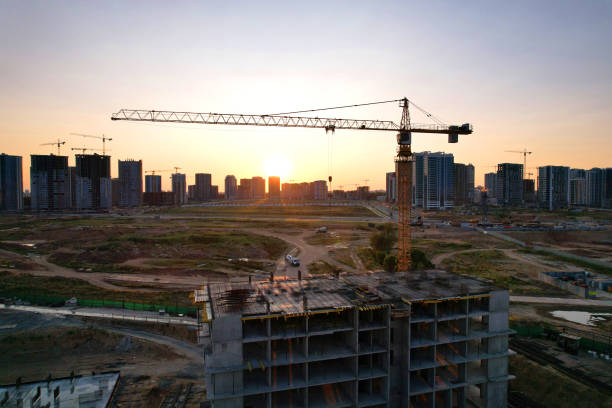 istock Tower crane on construction site on sunset background. Arial view of the cranes the conctruct the high-rise building. 1330593121