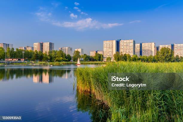 View At Tysiaclecie District In Katowice On A Beautiful Sunny Day Seen Through The Pond Apartment Buildings Situated Neat The Lake Against Blue Sky Stock Photo - Download Image Now