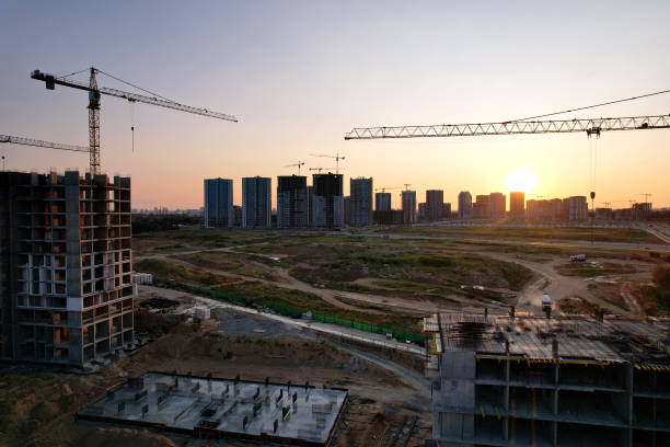 istock Tower crane on construction site on sunset background. Arial view of the cranes the conctruct the high-rise building. 1330594147