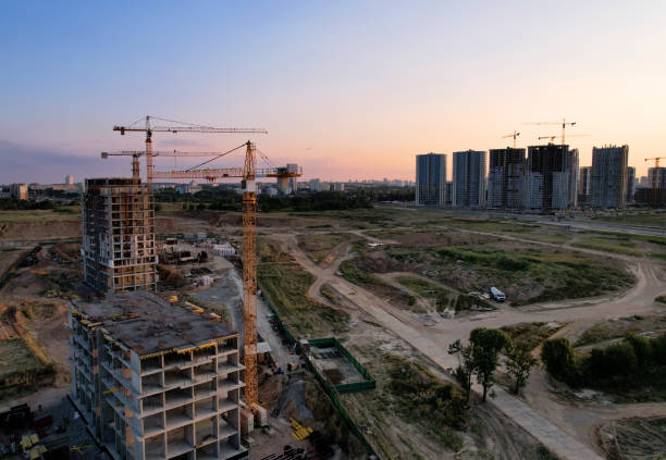 istock Tower crane on construction site on sunset background. Arial view of the cranes the conctruct the high-rise building. 1330594359
