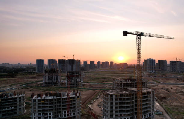 istock Tower crane on construction site on sunset background. Arial view of the cranes the conctruct the high-rise building. 1330594433