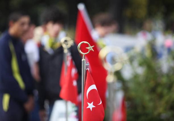 Turkish flag in Turkish martyrdom graveyard, there are people in the backplane.