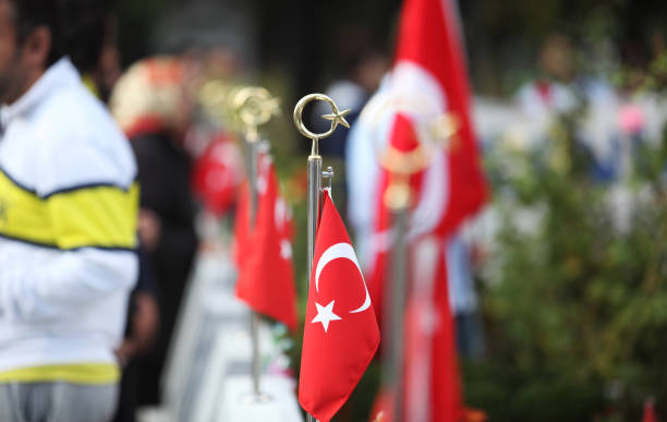 Turkish flag in Turkish martyrdom graveyard, there are people in the backplane.